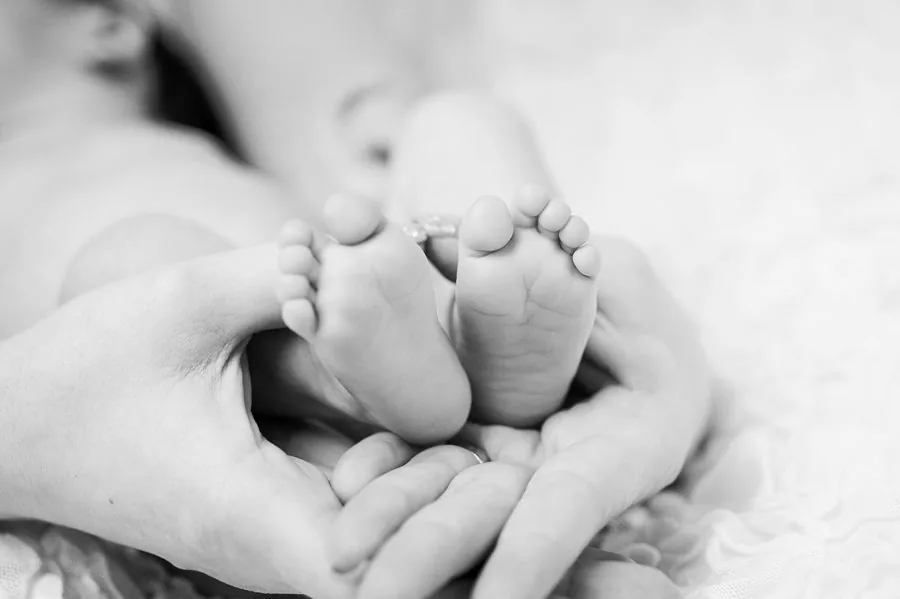 Pieds d'un nouveau-né tenus dans des mains