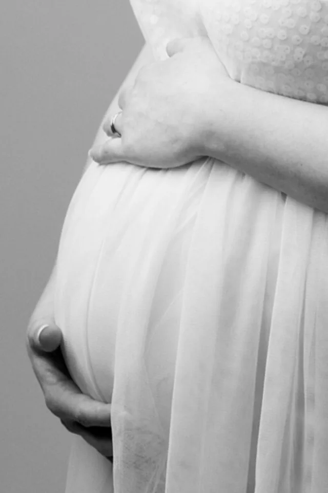 Femme enceinte, mains posées sur son ventre