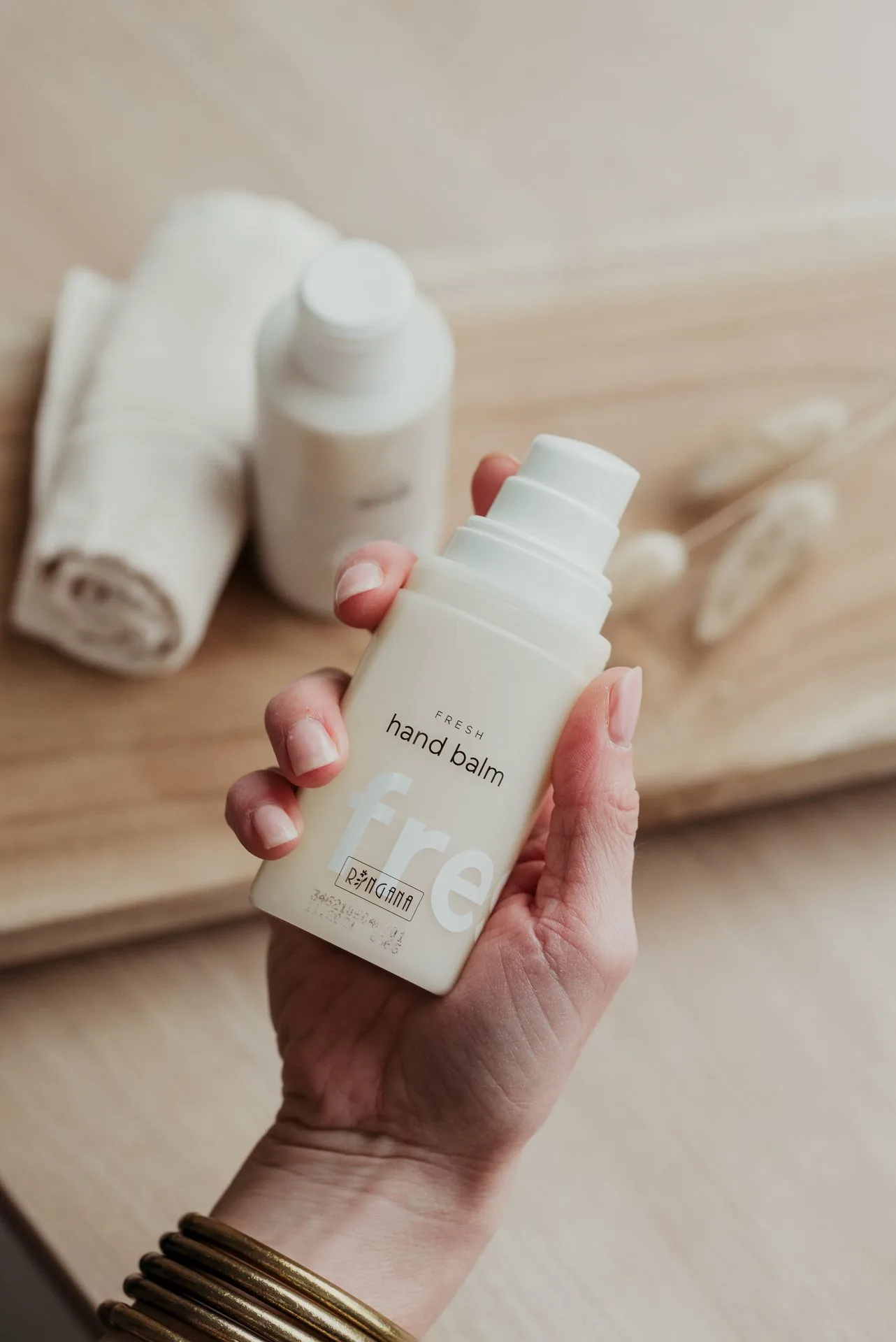 Baume pour les mains tenu au-dessus d'une serviette
